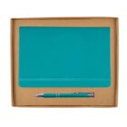 A teal notebook with an elastic band and a matching teal pen are placed inside a brown cardboard box. The pen has silver accents. The box is open, showcasing the items neatly arranged.