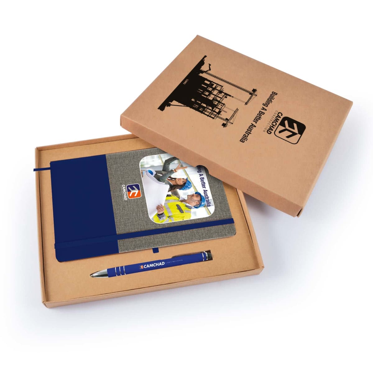 A cardboard box containing a notebook with a blue spine, a pen labeled CAMCHAD, and a brochure featuring construction workers. The box lid has an illustration of a construction site and the text Business Development Manager and EX.