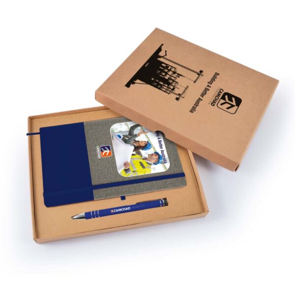 Open cardboard box containing a blue and gray notebook, a pen, and a brochure with construction-themed images. The box lid displays a crane silhouette and text related to construction engineering.