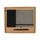 A gift set featuring a gray and black notebook with an elastic band next to a black and silver pen, all neatly arranged in a tan cardboard box.