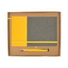 A boxed set containing a notebook and a pen. The notebook has a yellow and gray fabric cover with a yellow elastic band. The pen is yellow and silver. The items are placed in a brown cardboard box.