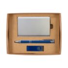 A cardboard box containing a silver business card holder, a blue and silver pen, and a blue USB flash drive. The items are neatly arranged within the box on a neutral background.