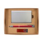 A cardboard gift box containing a silver business card holder, a red pen with silver accents, and a red USB flash drive with black detailing.