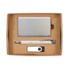 A gift box containing a metallic cardholder, a white pen with silver accents, and a black and white USB flash drive, all placed neatly inside a plain brown box with a clear lid.