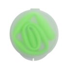 A coiled, green silicone straw inside a translucent white circular container, viewed from above. The containers lid is partially visible, with the coil forming a soft spiral pattern.