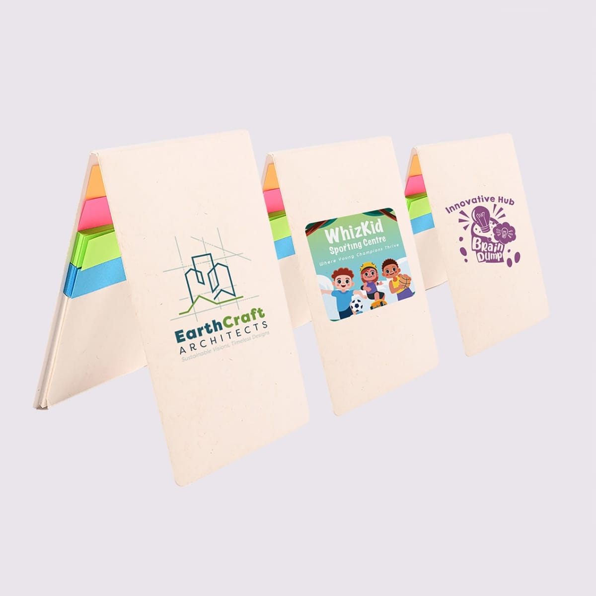 Three standing promotional notepads with colorful sticky notes inside. Covers display logos: EarthCraft Architects with a building design, WhizKid Sporting Centre with cartoon kids, and Innovative Hub Brain Dump with a stylized brain.