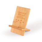 Wooden phone stand featuring the engraved text Coastal Blend Cafe & Restaurant with coffee bean motifs. The stand has a slanted back support and a base to hold a phone.
