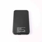 A black rectangular power bank with white text and specifications printed on it, placed against a plain white background.