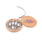 A round wooden case with a lid partially open, revealing four USB adapters inside. The lids top has a colorful soundwave design. A gray lanyard is attached to the side of the case.