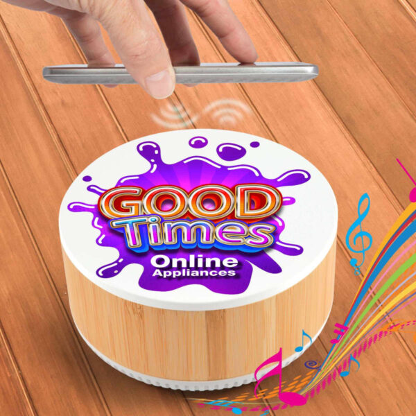 A hand hovers over a small, round speaker labeled Good Times Online Appliances on a wooden surface. Vibrant music notes and colorful stripes emanate from the speaker, suggesting it is playing music.