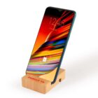 Smartphone in a wooden stand labeled Family TV, displaying a colorful screen with the date Friday, May 11 and a lock icon, indicating its locked.