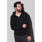 Man in a black hoodie looks to the side against a gray background.