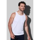 Smiling man in a white tank top and black shorts against a gray background.