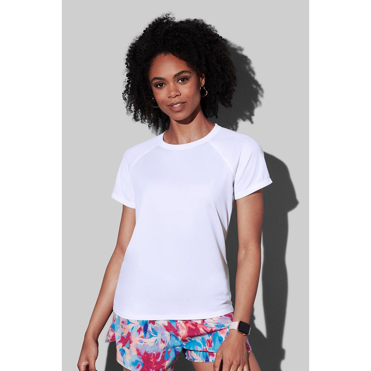 Person in white shirt and colorful shorts against a gray background.