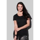 Smiling woman in a black t-shirt and patterned leggings against a gray background.