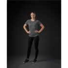 Person in athletic wear stands confidently against a dark background.