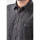 Man wearing a dark gray button-up shirt with a pocket on the chest.
