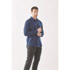 Person in a blue shirt and black pants stands against a plain background.