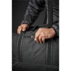 Person holding a black bag with a zipper.