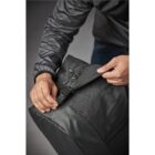 Person adjusting a strap on a black backpack.