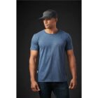 Man in blue t-shirt and black cap standing, looking to the side against a dark background.
