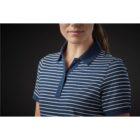 Person wearing a navy and white striped polo shirt on a dark background.