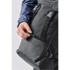 Hand holding a black backpack, unzipping a pocket.