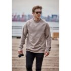 A person in sunglasses walks on a dock holding a camera.