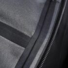 Close-up of a black zipper on a textured gray fabric surface.