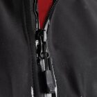 Close-up of a black waterproof jacket zipper with red lining.