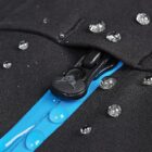 Close-up of water droplets on black fabric with a blue zippered seam.