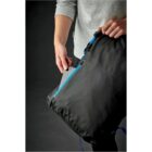 Person placing a tablet into a black bag with a blue zipper.