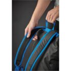 A person adjusts the blue straps on a black backpack.