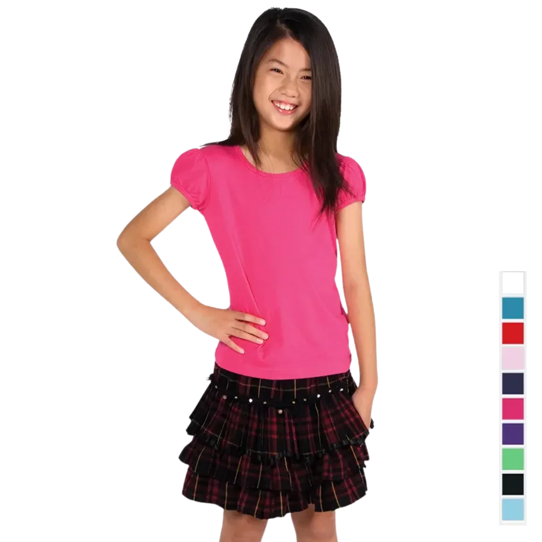 Girl in ComfyCotton Girls Tee and black plaid skirt with hand on hip.