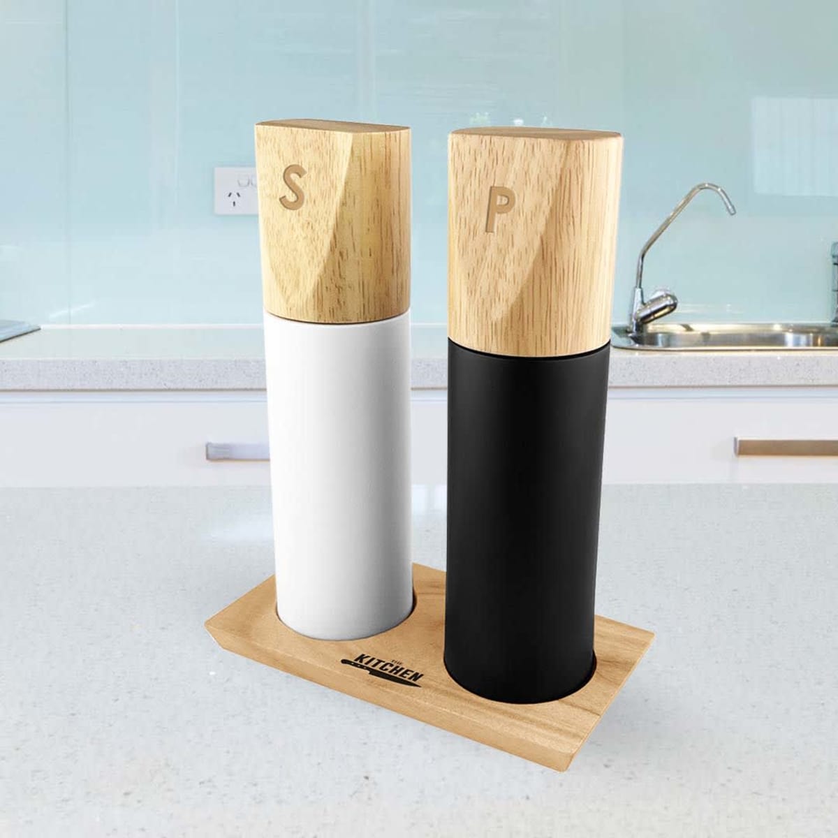 Salt and pepper grinders with wooden tops on a stand in a modern kitchen.