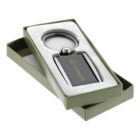 A keychain with a logo inside an open green box with white padding.