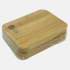 Three stacked bamboo cutting boards wrapped in plastic. Each board has rounded corners and a circular hanging hole in one corner. The boards are placed on a plain white background.