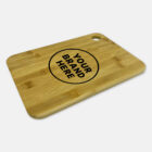 A rectangular wooden cutting board with a hole in one corner. It has the words Your Brand Here inside a circular border printed in black on the surface. The board is set against a plain white background.