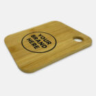 Wooden cutting board with a rounded corner and a circular hole for hanging. The board features a black circle with the text YOUR BRAND HERE inside, suggesting space for customization or branding.