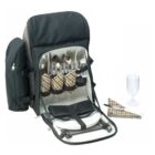 A black picnic backpack with its front unzipped, revealing neatly organized compartments holding cutlery, wine glasses, plates, napkins, and salt and pepper shakers. A folded tartan-pattern napkin and a glass are placed beside it.