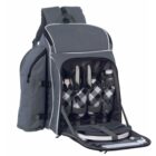 Gray picnic backpack with open front compartment revealing a set for four: plates, utensils, and checkered napkins, plus two bottles. Multiple additional pockets visible.