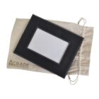 Black leather photo frame with white stitching placed on a beige drawstring bag. The bag has AGRADE printed on it. The frames interior is white, ready for a photo insert.