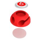 Exploded view of a red, round protective case with three layers shown separately. The top layer is a white circular cap with a red logo, the middle is the red casing with openings, and the bottom is a flat, white disc.