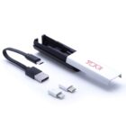 A compact electronics kit is shown, featuring a black USB cable with a micro USB connector, a white adapter with a lightning connector, and a USB-C adapter. The items are displayed alongside a branded white and black carrying case.