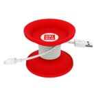 A red circular cable organizer with the Uniqlo logo is shown. A white USB and lightning cable is neatly wrapped around the spool, with the connectors visible.
