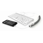 A black smartphone is connected to a compact white keyboard via a short white cable. The keyboard is linked to a curved gray external battery on the right, which displays a small indicator light.