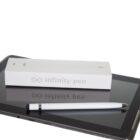 A stylus pen is resting on a tablet screen. Behind it is a white box labeled infinity pen with a minimalist pen illustration and an infinity symbol. The background is plain white.