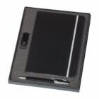 A gift set inside a foam-lined box featuring a closed black notebook with a white vertical stripe, a black pen with silver accents, and a USB flash drive. The items are neatly arranged in individual compartments.