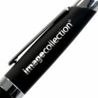 A close-up of a black pen with silver accents. The pen has the word imagecollection printed in silver on its body.