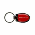 A metal keychain with a red plastic center labeled image collection. The keychain has a round ring for attaching keys and a teardrop-shaped body.